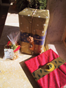 Scraps of tissue paper mix with a strip from a fleur-de-lis-printed bag. The pom-pom is trimmed with beads.